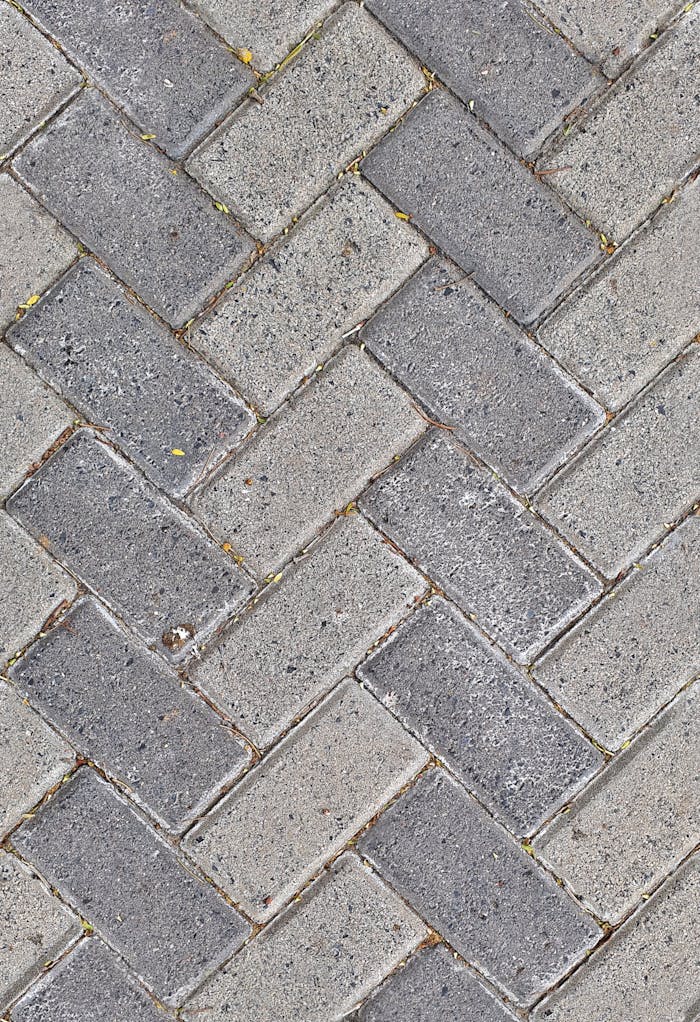 Close-up of gray brick patterned pavement, offering texture and design details.