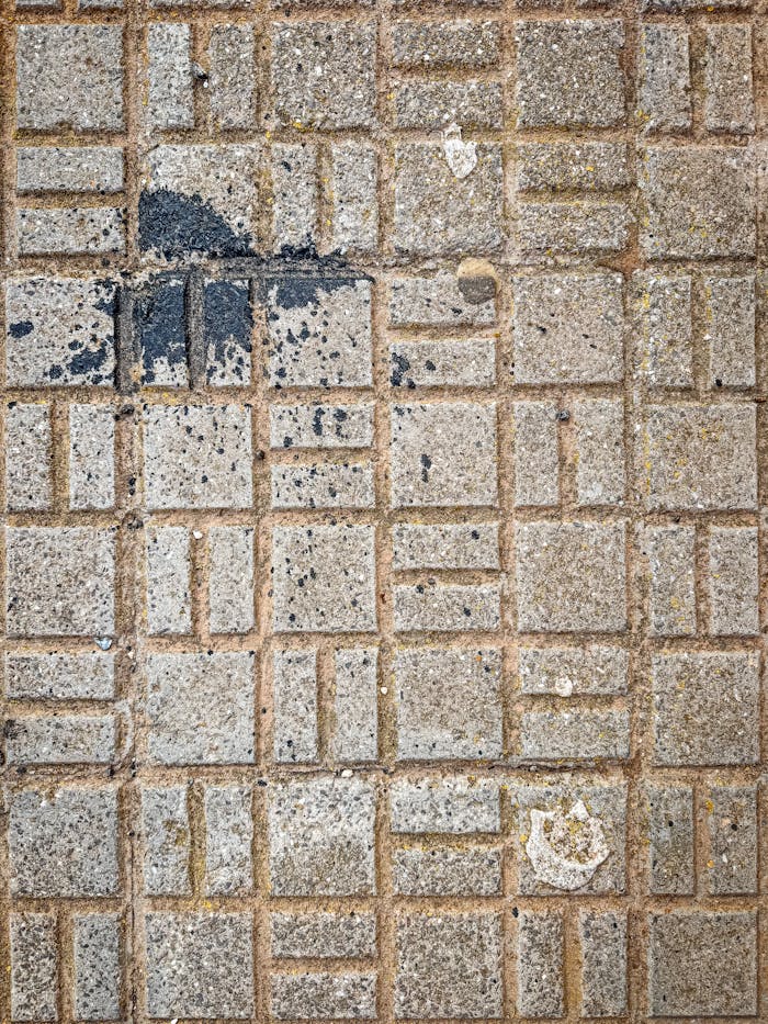 Close-up of stone pavement with dark stains in Santiago de la Ribera, Spain.